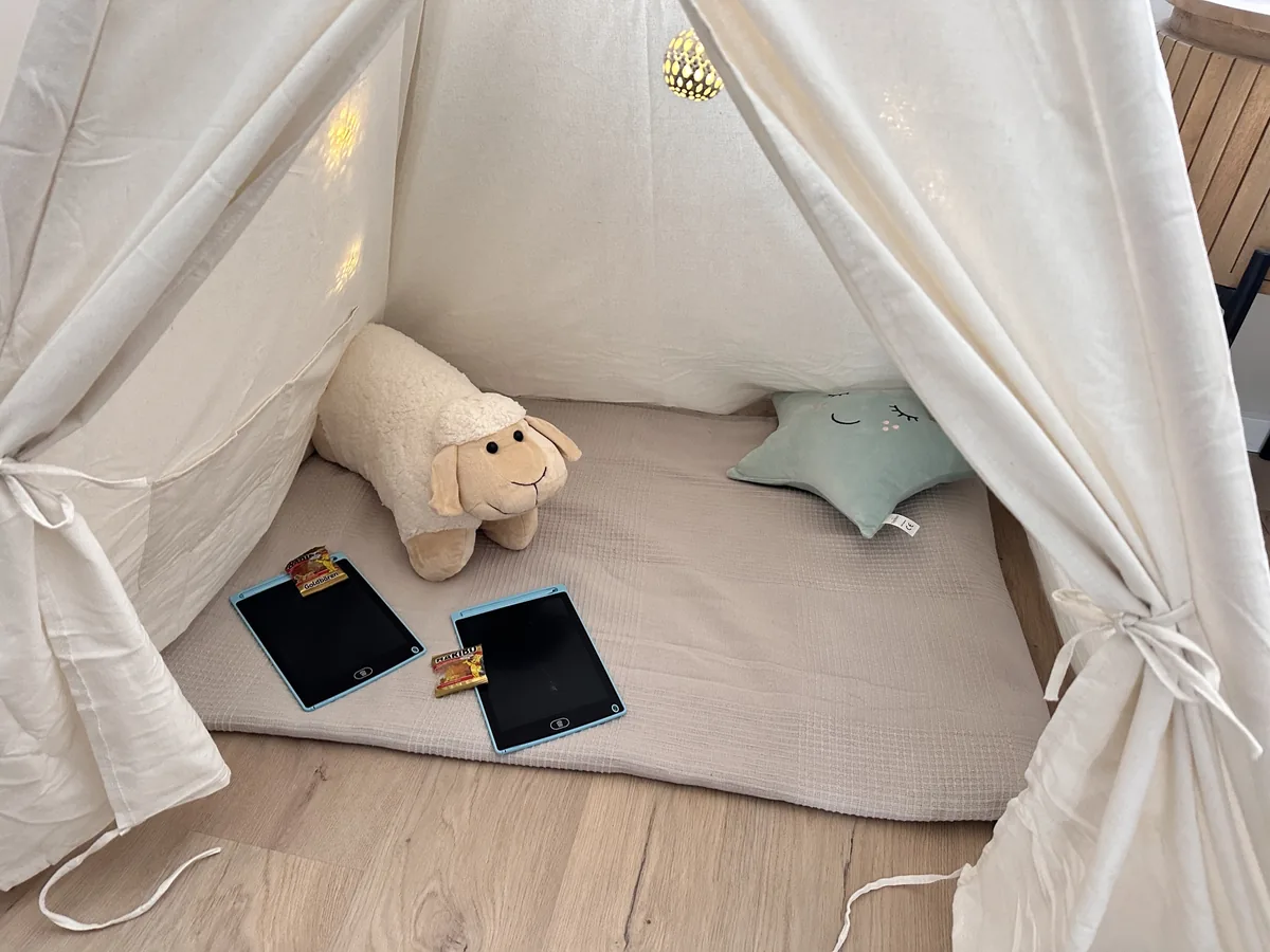 Blick ins Tipi: Bodenkissen, Kuscheltier Schaf und zwei Maltafeln