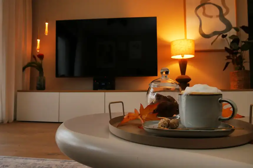 Wohnzimmer am Abend mit Kaffee, Kerzen und Herbstlaub