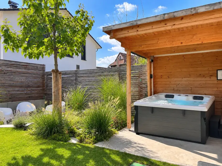Privater Whirlpool unter Holzpergola im Garten der WolkenGuckerei