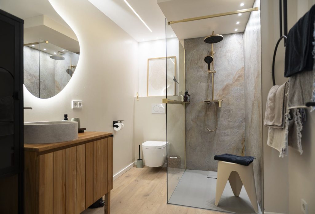Bad WolkenGarten Modern Duschbereich mit marmoriertem Wänden, goldenen Armaturen und Handtuchhalter.