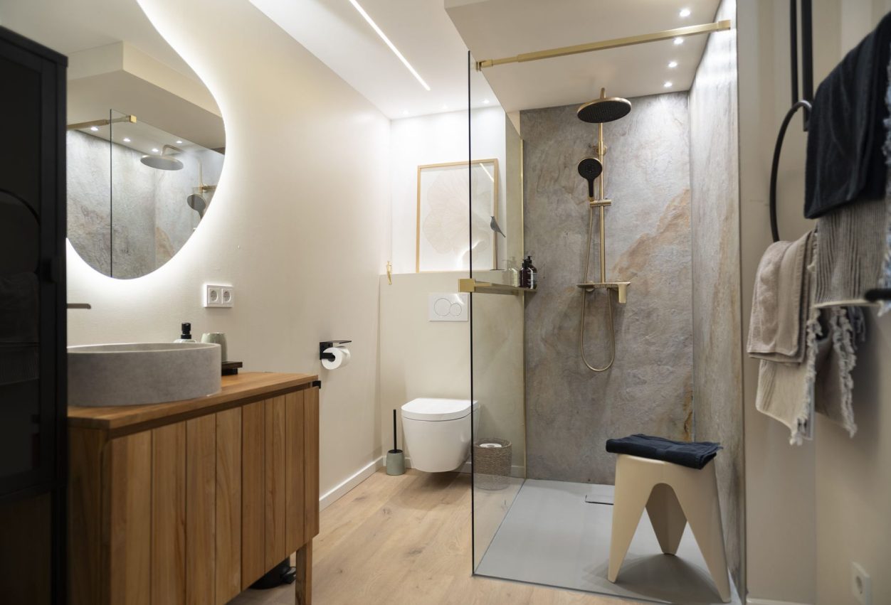 Bad WolkenGarten Modern Duschbereich mit marmoriertem Wänden, goldenen Armaturen und Handtuchhalter.
