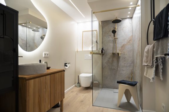 Regendusche Modernes Badezimmer mit Dusche, WC, Waschtisch aus Holz und Handtüchern.
