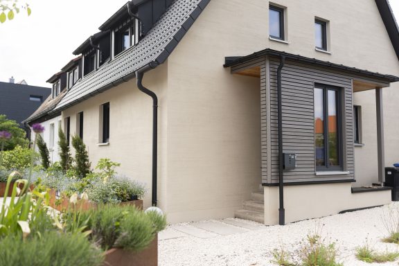 Eingang mit Briefkasten und Schlüsselbox Moderne Hausansicht mit geradem Eingang und gepflegtem Garten.