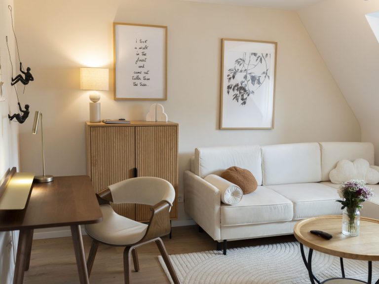Wohnzimmer Heller Wohnraum mit Wohnzimmermöbeln, Pflanzen und dekorativen Bildern an der Wand.