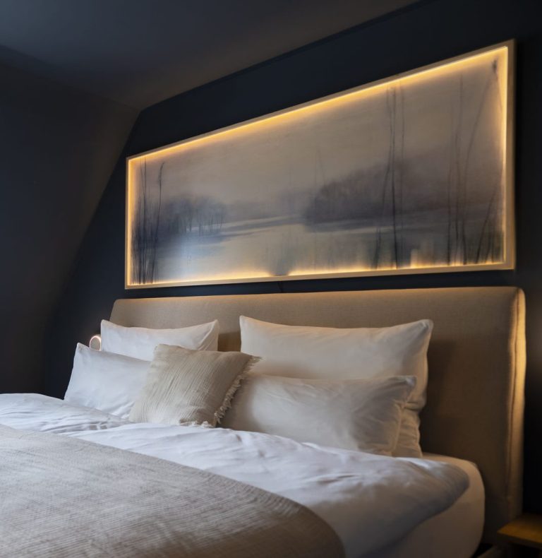 Schlafzimmer Modern Schlafzimmer mit einem hell erleuchteten Kunstwerk über dem Bett.