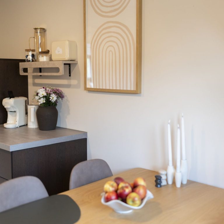 Küche Moderne Küche mit Esstisch, Obstschale, Pflanzen und ansprechender Wanddekoration.