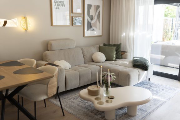 Wohnzimmer WolkenGarten Helles Wohnzimmer mit moderner Couch, Tisch und dekorativen Elementen.