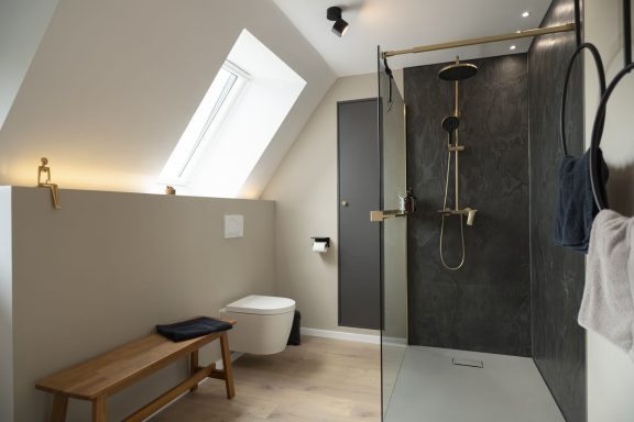 Regendusche Modernes Badezimmer mit Dusche, WC, und Holzbank unter Dachfenster.