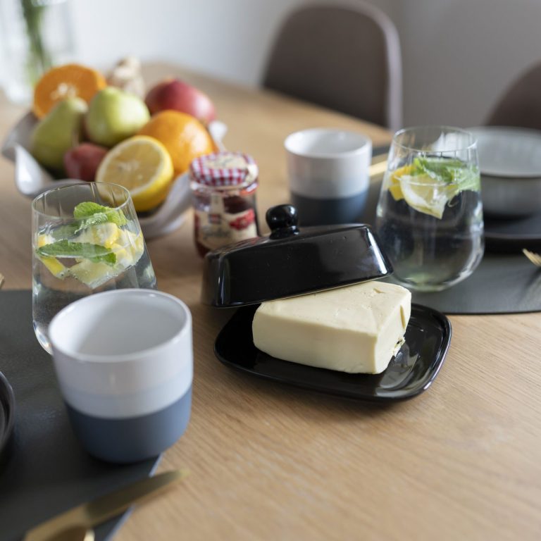 Frühstück Tischgedeck mit Früchten, Gläsern, Tassen, Käse und Marmelade.
