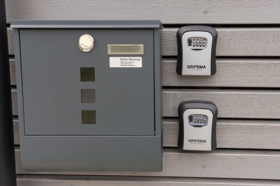 Grauer Briefkasten und zwei Schlüsselboxen