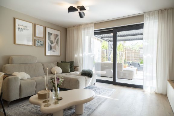 GartenBlick Helles Wohzimmer mit moderner Einrichtung, großen Fenstern und Zugang zur Terrasse.